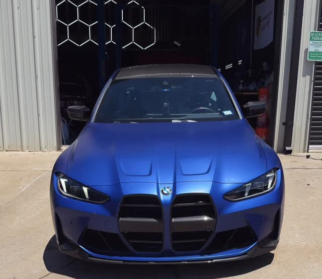 Blue BMW car parked in front of a garage door